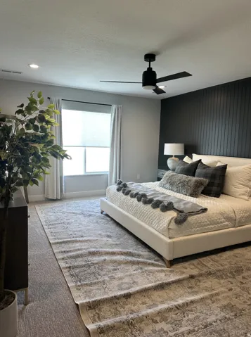 Bedroom with a textured ceiling, a ceiling fan, and carpet floors