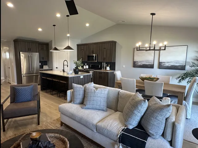 Living room with light wood-style floors, lofted ceiling, a chandelier, and recessed lighting