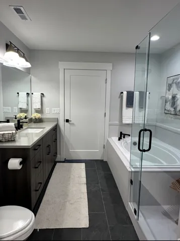 Bathroom with a garden tub, vanity, and a stall shower