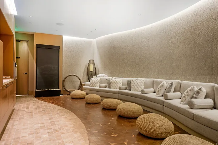 Curved seating area featuring a textured wall, built-in wall niche lighting, and a water feature