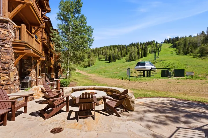 Stone patio with a built-in fire pit, stone benches, and a flagstone surface