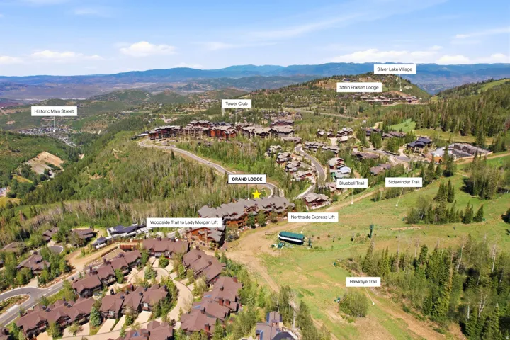 Aerial perspective showcasing a mountain community with extensive natural landscaping and multiple residential structures