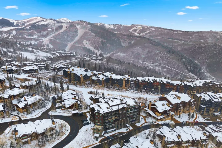 Snow-covered mountain community featuring multiple residential buildings with varied architectural styles