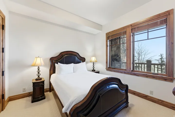 Bedroom featuring light-toned carpeting, white walls, and substantial wood trim