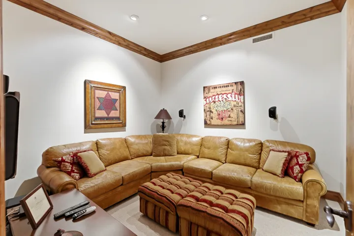 Entertainment room featuring recessed lighting, a built-in sound system, and wood crown molding