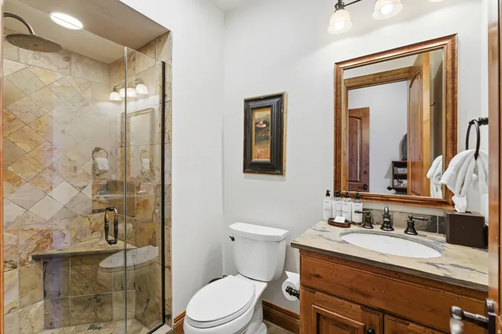 Bathroom featuring a glass-enclosed shower with tile surround and built-in bench