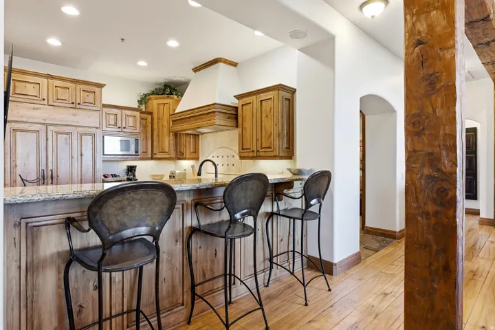 Kitchen featuring wood-finish cabinetry with panel doors, granite countertops, and a built-in microwave