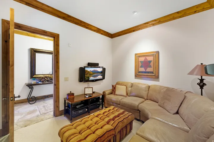Cozy media space featuring recessed lighting and wood beam detailing