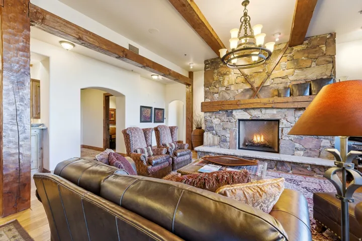 Stone fireplace featuring a natural wood mantle