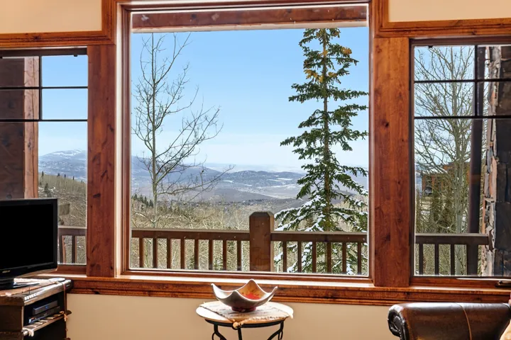 Expansive picture window framed by rich wood millwork showcasing distant mountain scenery