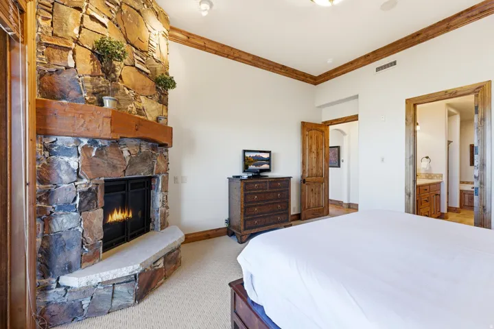 Stone-clad fireplace with a natural wood mantel
