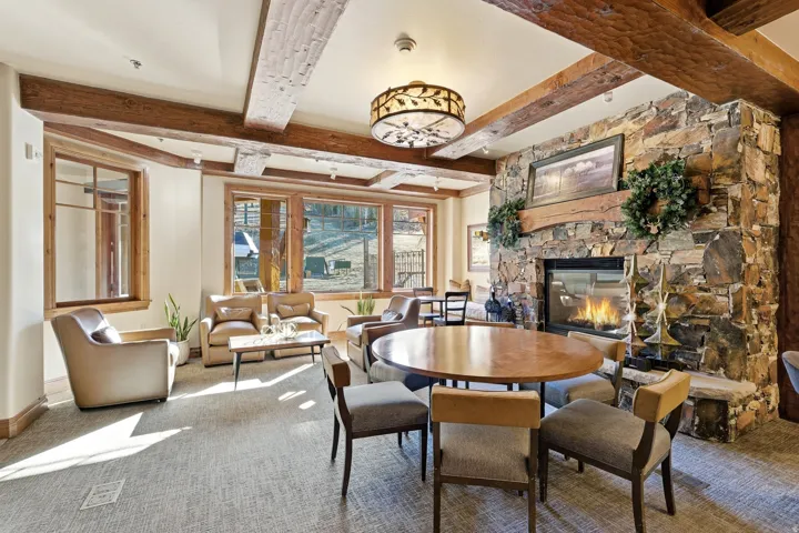 Stone accent wall with a built-in fireplace, wood mantle, and hearth