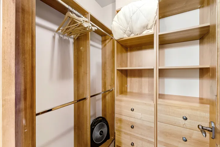 Custom closet system featuring light wood-finish cabinetry