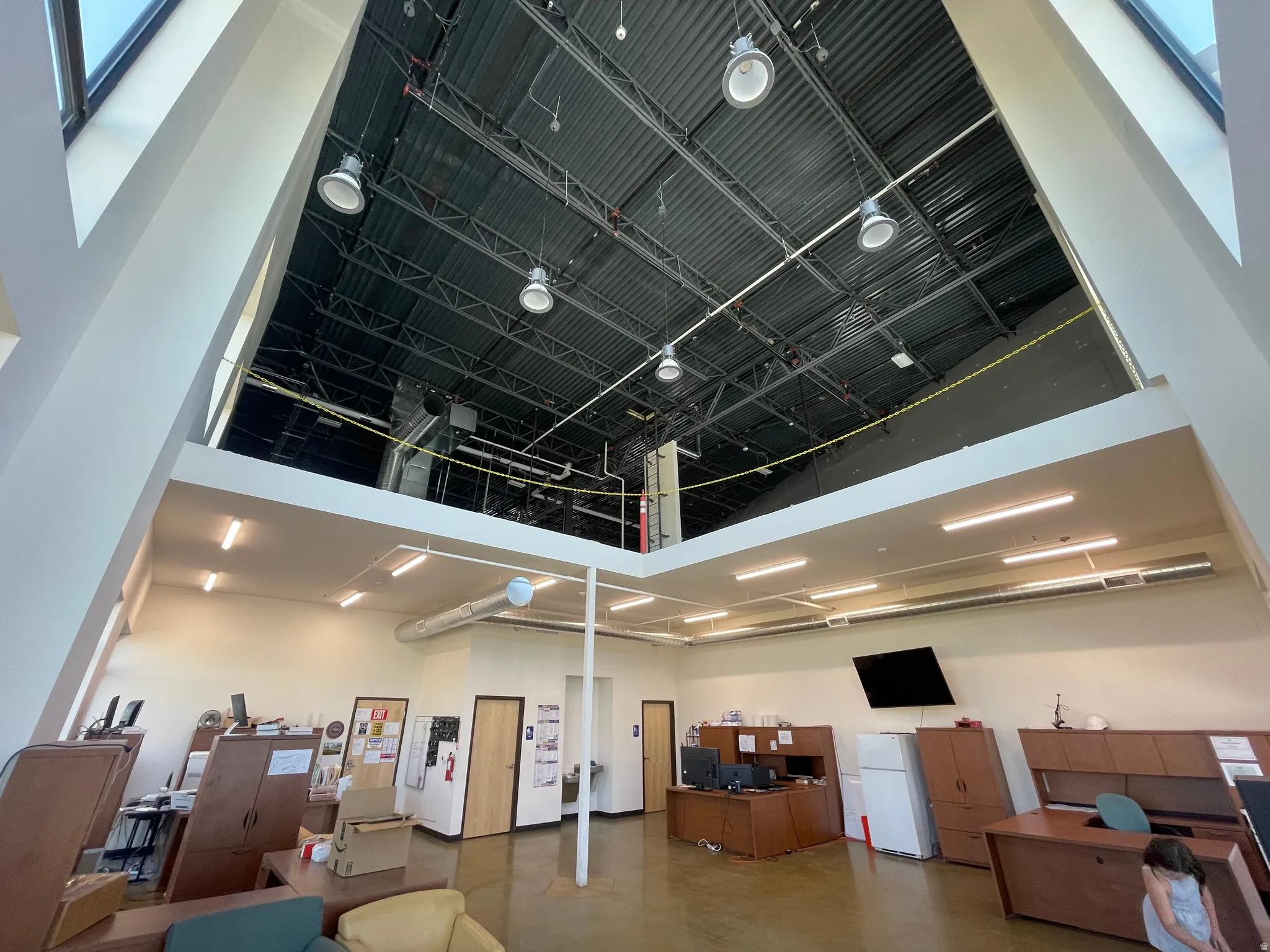 Misc room featuring a towering ceiling and a desk