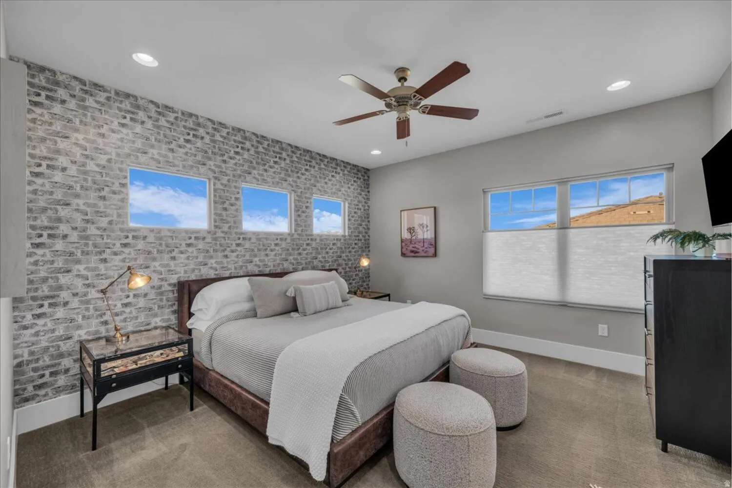 Bedroom with brick wall, an accent wall, light carpet, ceiling fan, and recessed lighting