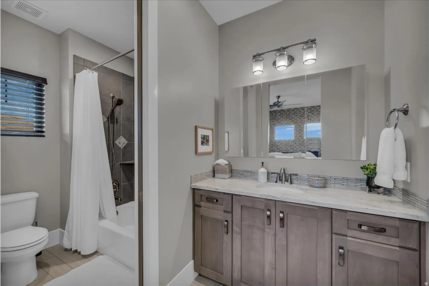 Bathroom featuring shower / tub combo with curtain, vanity, and ceiling fan