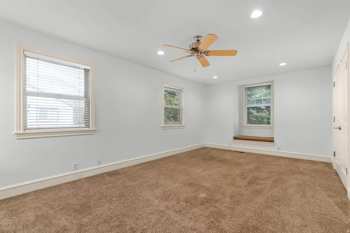 Empty room with recessed lighting, light colored carpet, and a ceiling fan