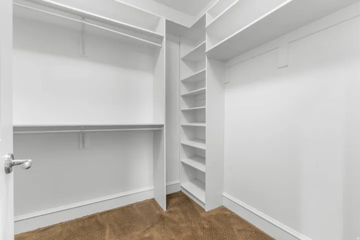 Walk in closet featuring dark carpet