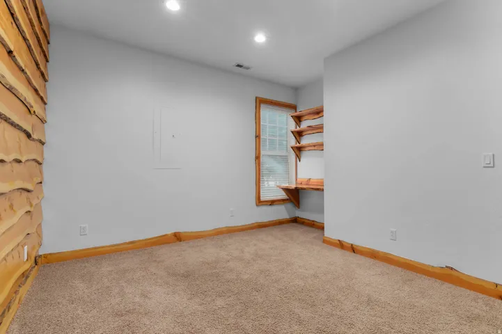 Empty room with light carpet and recessed lighting