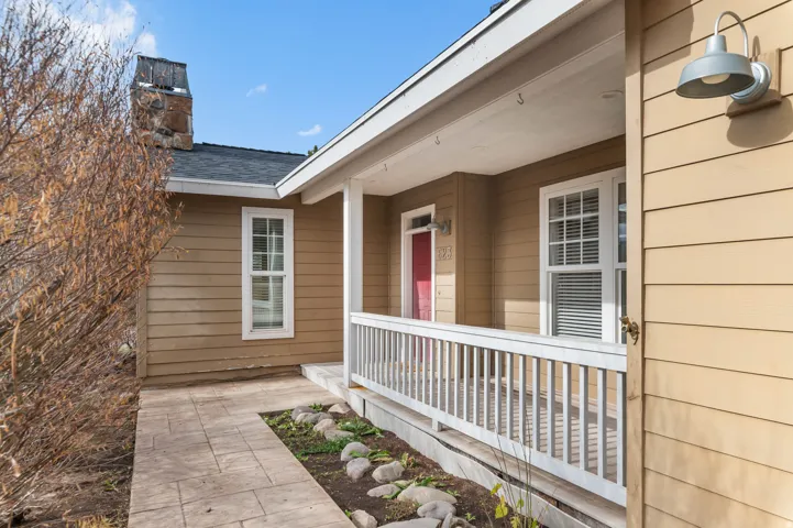 Property entrance featuring a porch and a chimney