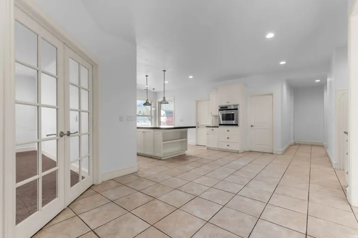 Kitchen featuring dark countertops, hanging light fixtures, open shelves, recessed lighting, and stainless steel oven
