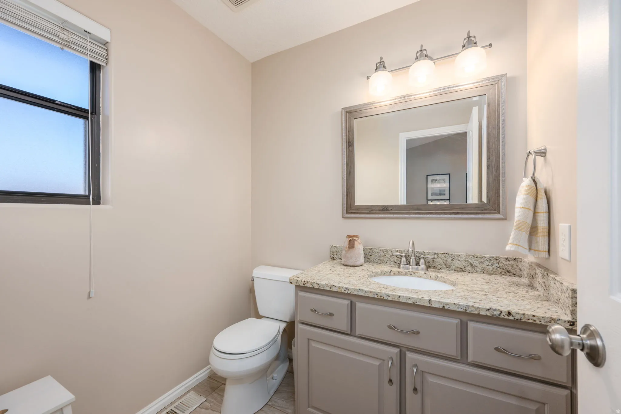 Half bathroom with vanity and toilet