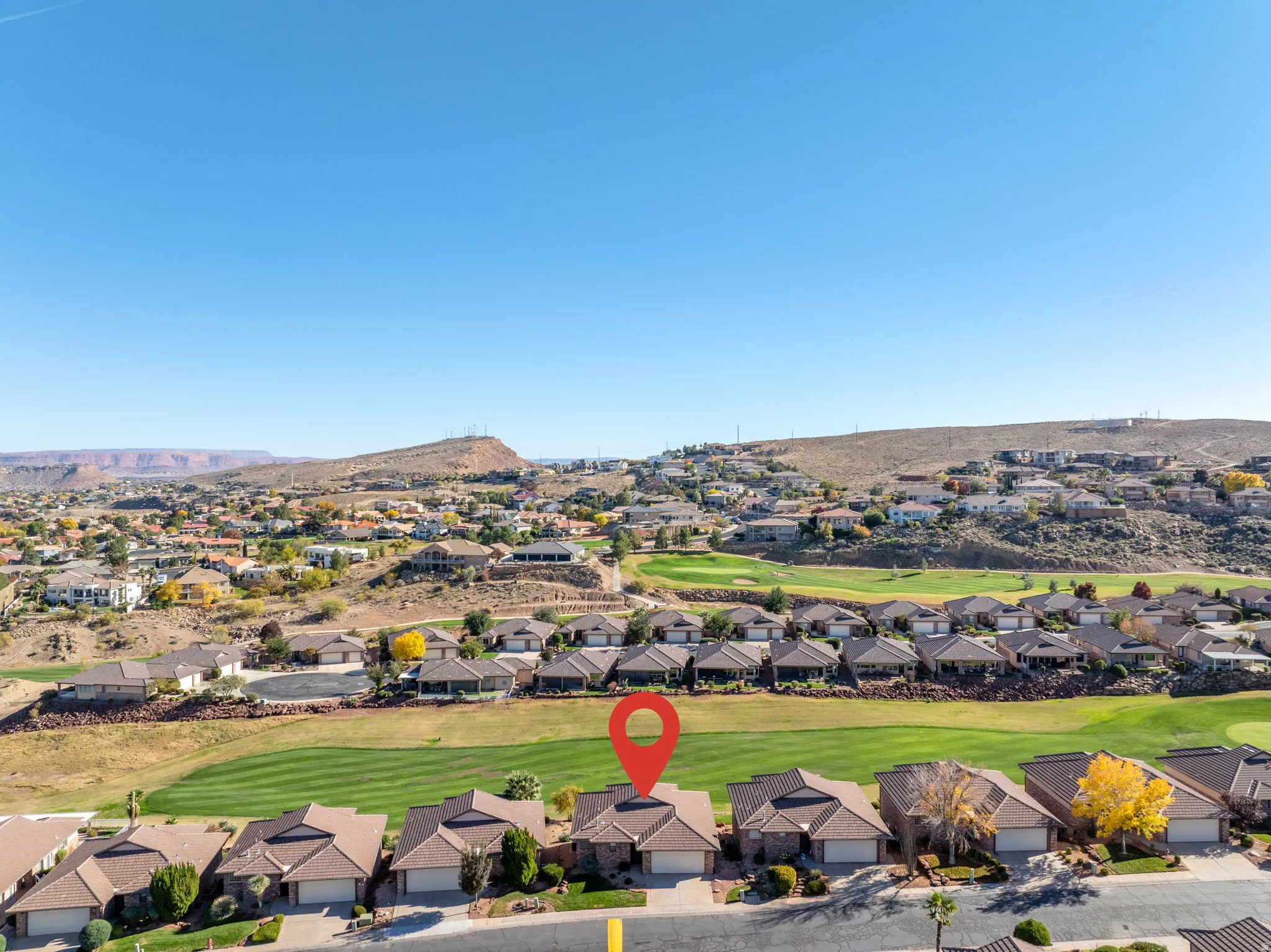 Aerial view of residential area with a golf course and a mountain backdrop
