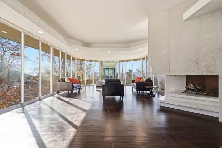 Living room featuring expansive windows, a tray ceiling, dark wood-style floors, and recessed lighting