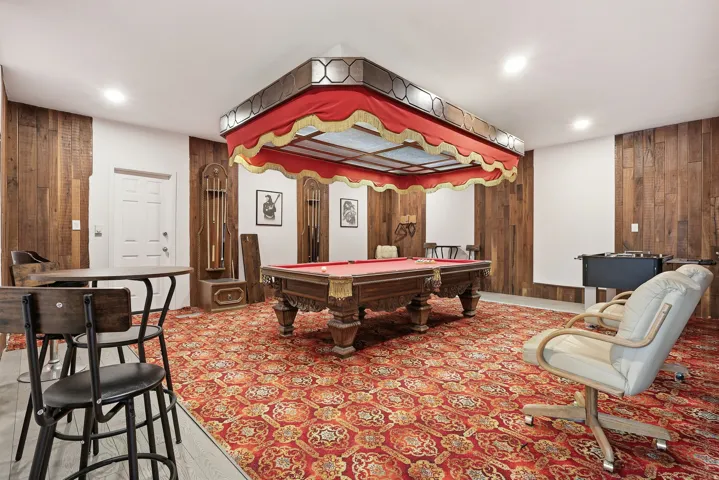 Game room with wooden walls and billiards table