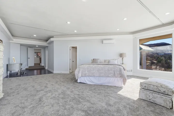 Bedroom featuring carpet floors, recessed lighting, and a wall mounted AC