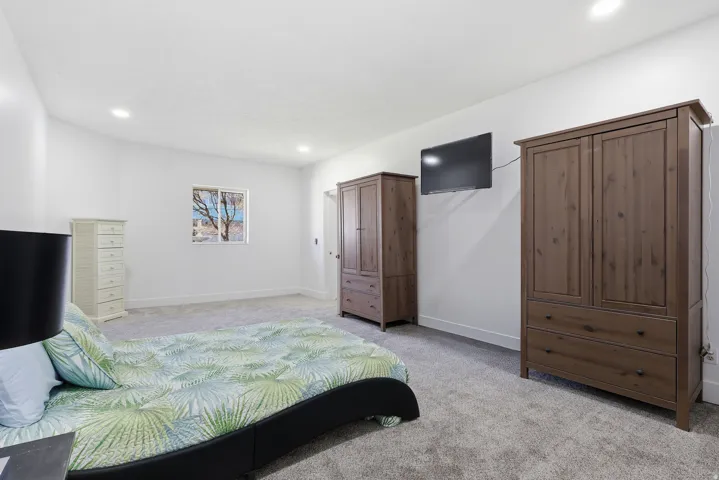 Bedroom with light colored carpet and recessed lighting