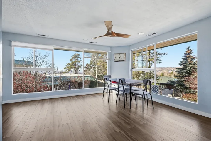 Dining space featuring wood finished floors, ceiling fan, healthy amount of natural light, and a textured ceiling