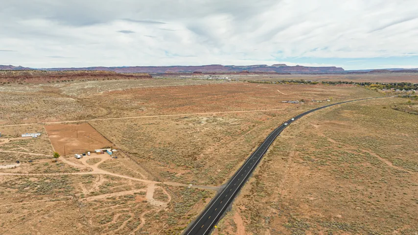Aerial view of property and surrounding area featuring a mountainous background and rural landscape