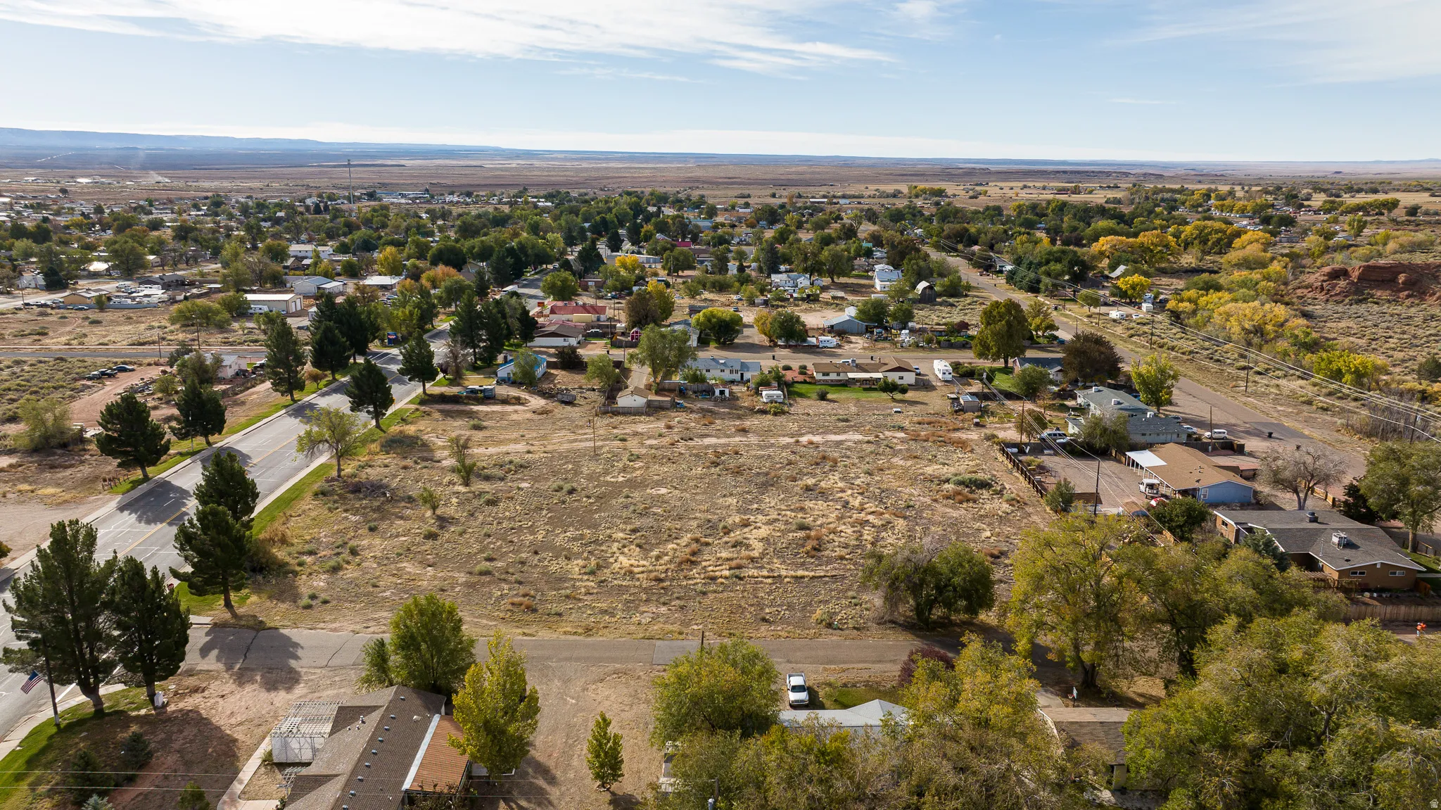 Aerial view of property and surrounding area featuring nearby suburban area and rural landscape