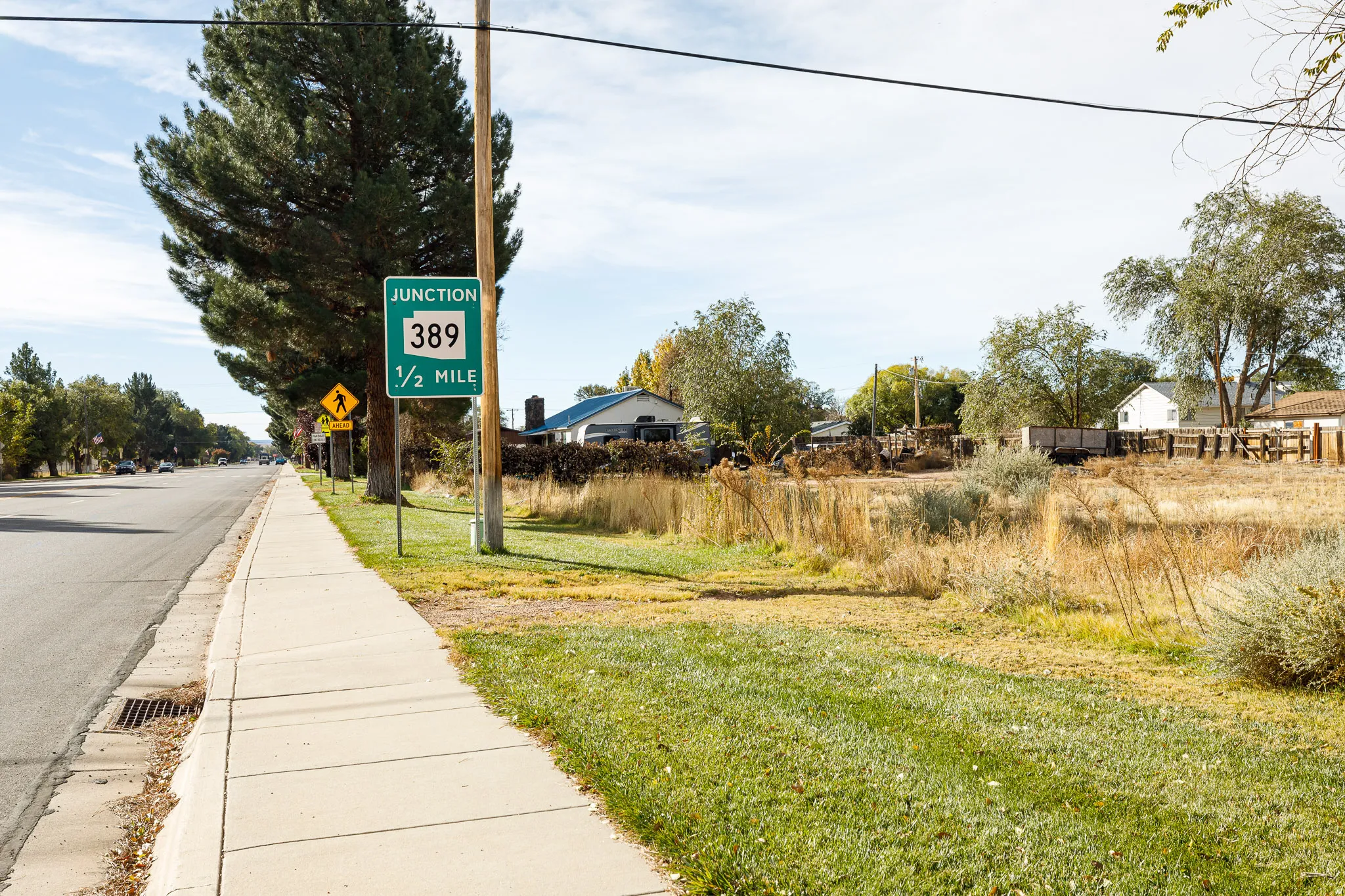 View of asphalt road featuring sidewalks and traffic signs