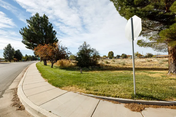 View of asphalt street featuring curbs, traffic signs, and sidewalks