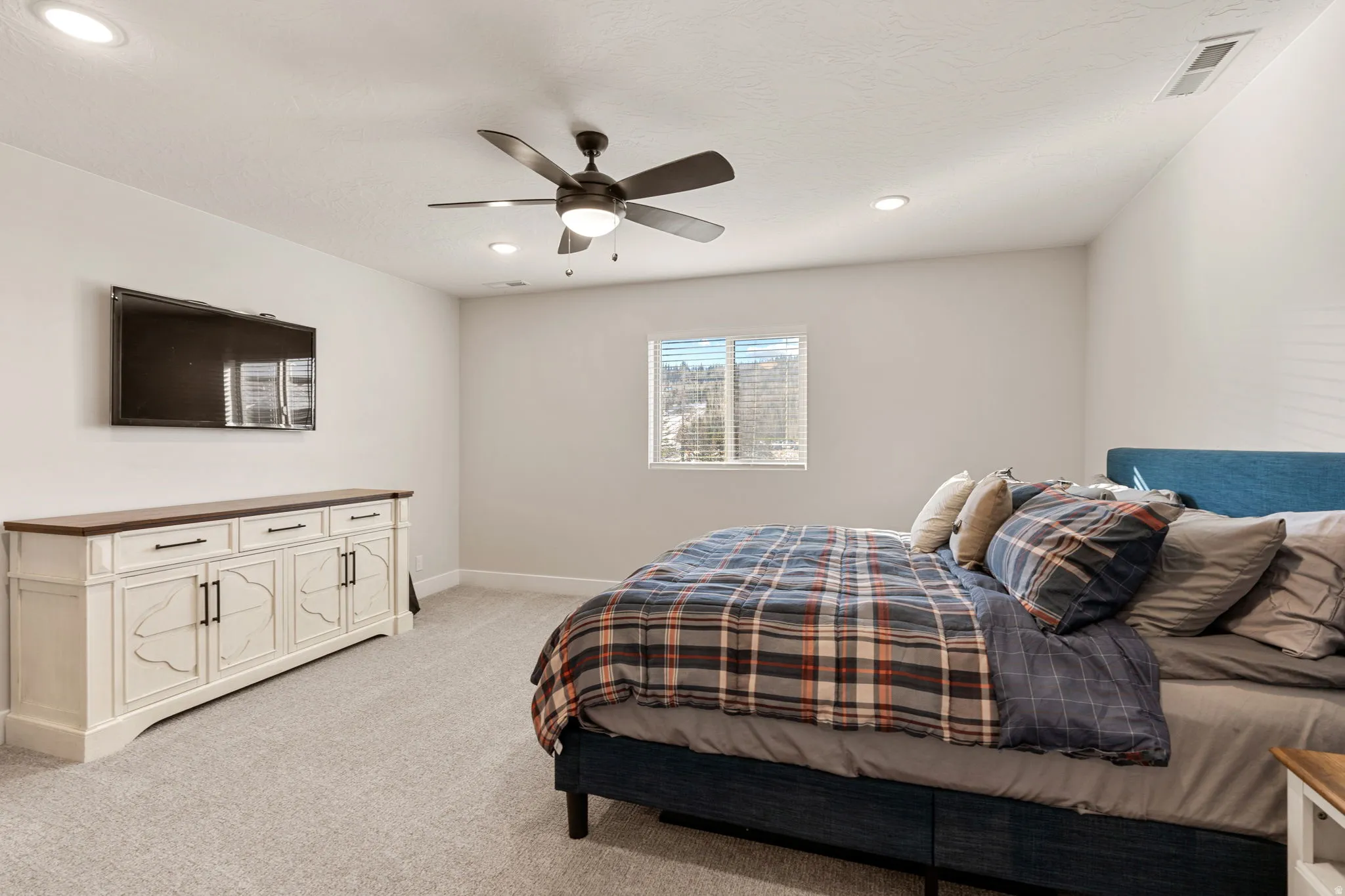 Bedroom with light colored carpet, ceiling fan, and recessed lighting