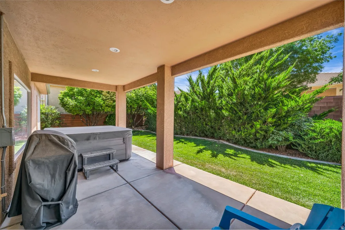 Fenced backyard with a patio area and a hot tub