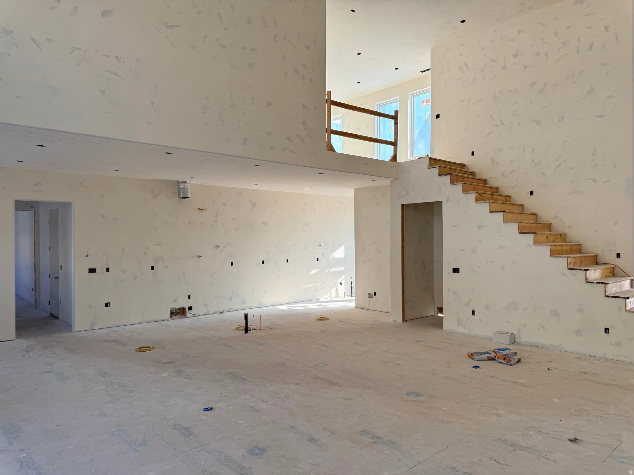 Unfurnished living room featuring a towering ceiling