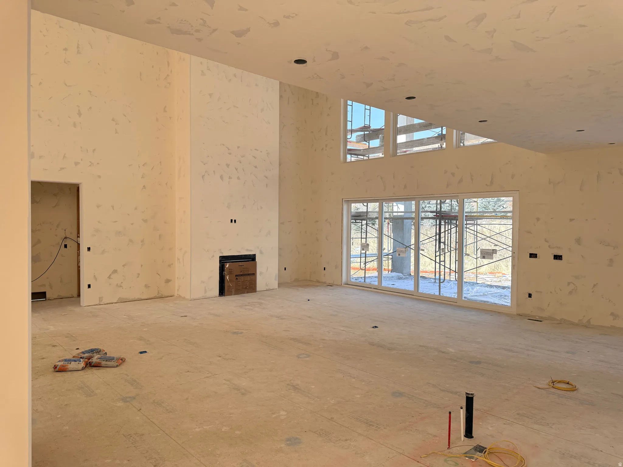 Unfurnished living room featuring a towering ceiling