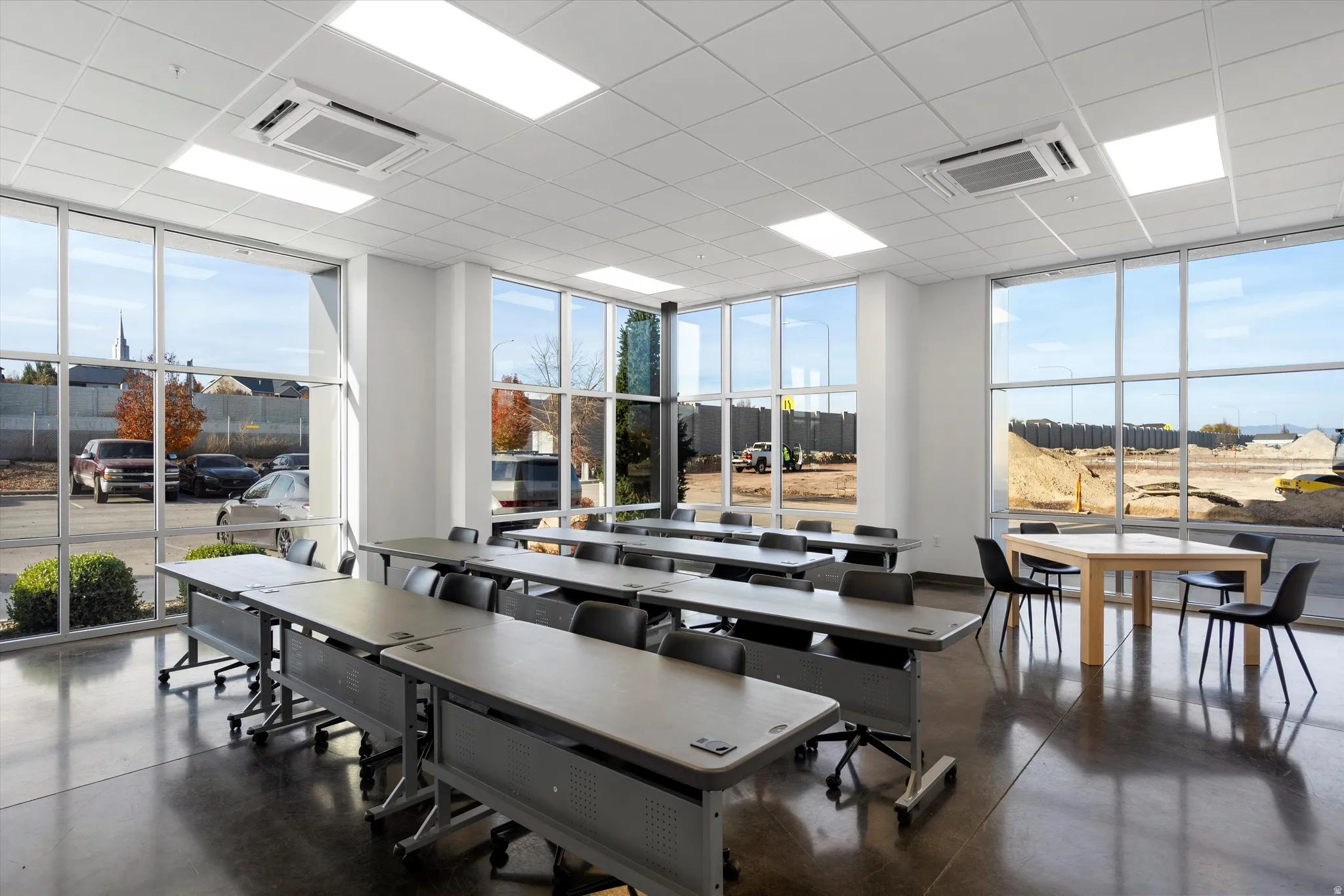 Training/Gathering room with a wall of windows, concrete flooring, and healthy amount of natural light