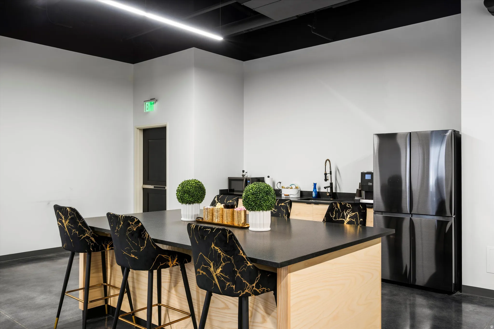 Kitchen with freestanding refrigerator, granite countertops, stainless steel microwave, and a breakfast bar