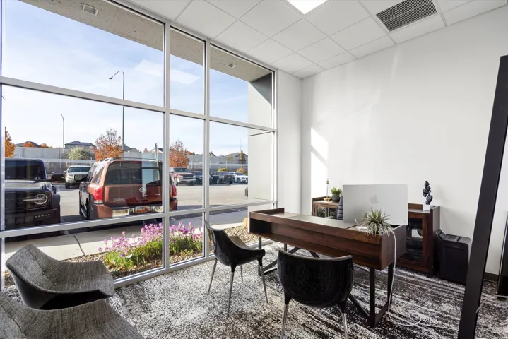 Office space with floor to ceiling windows and a drop ceiling