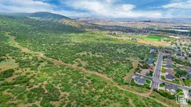 Aerial view of property and surrounding area featuring a mountain backdrop and property parcel outlined