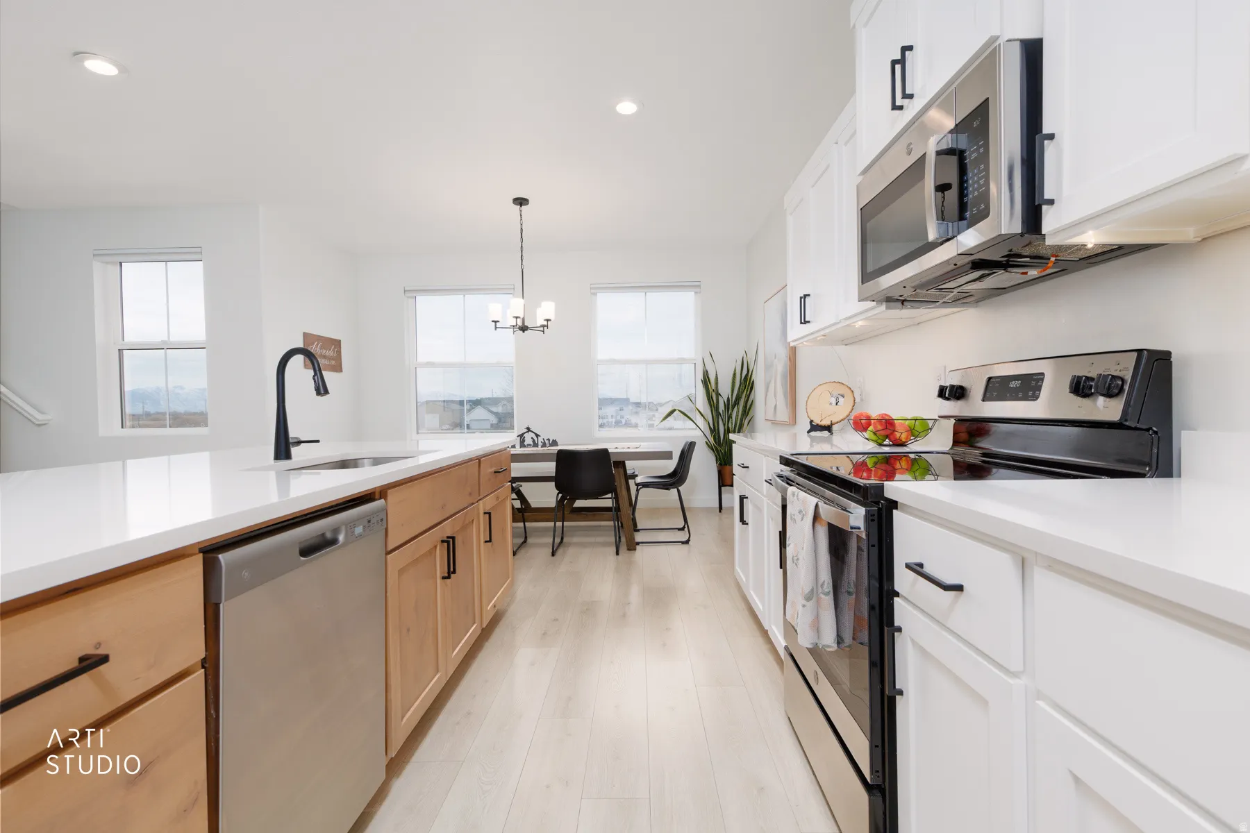 Kitchen with stainless steel appliances, white cabinetry, recessed lighting, pendant lighting, and light wood-style floors