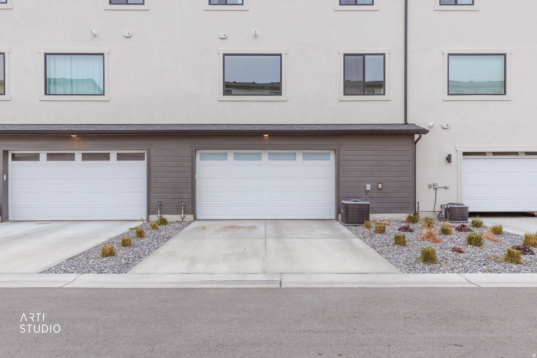 View of front of house with driveway, stucco siding, and an attached garage