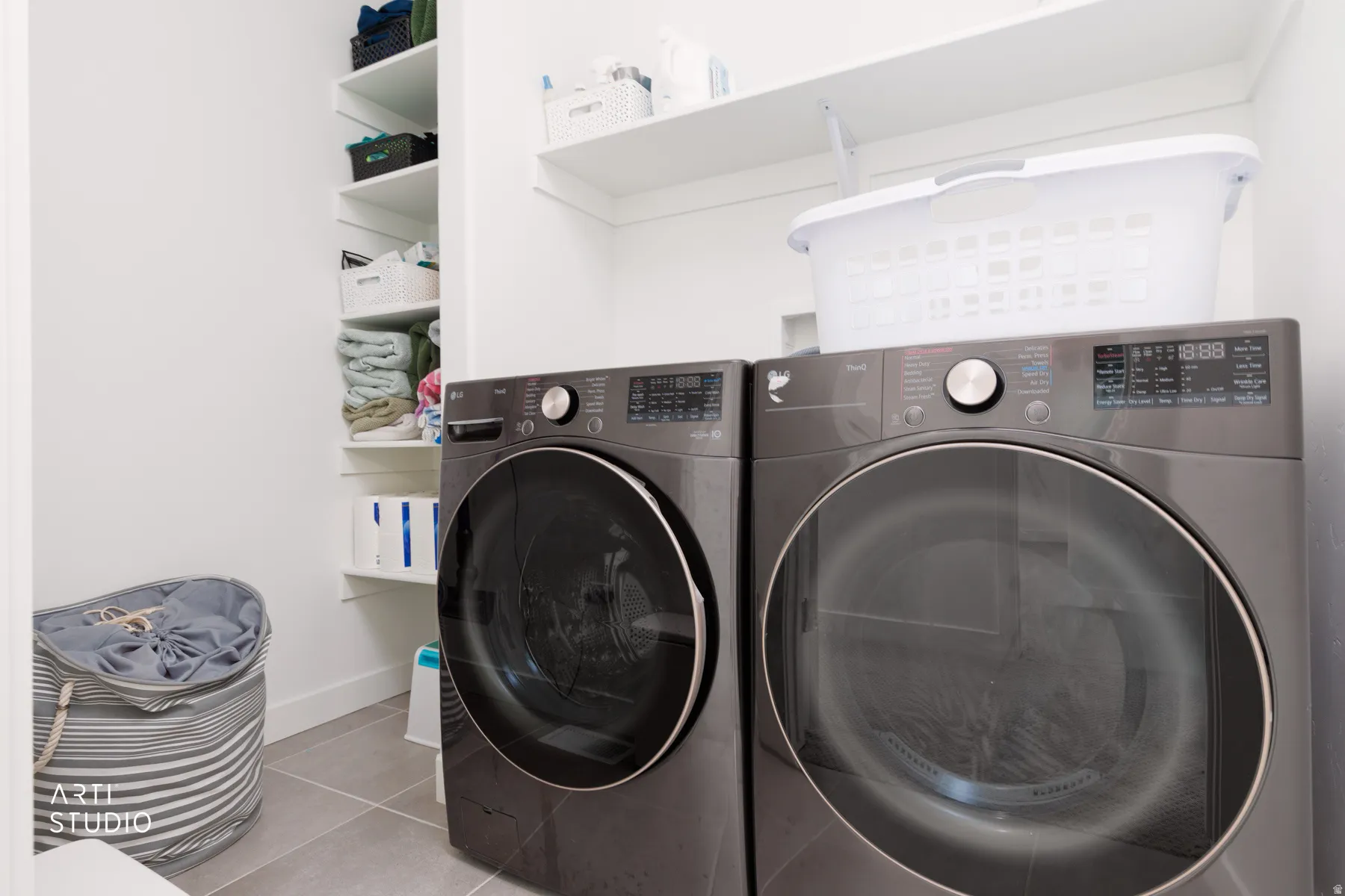 Washroom with light tile patterned floors and separate washer and dryer