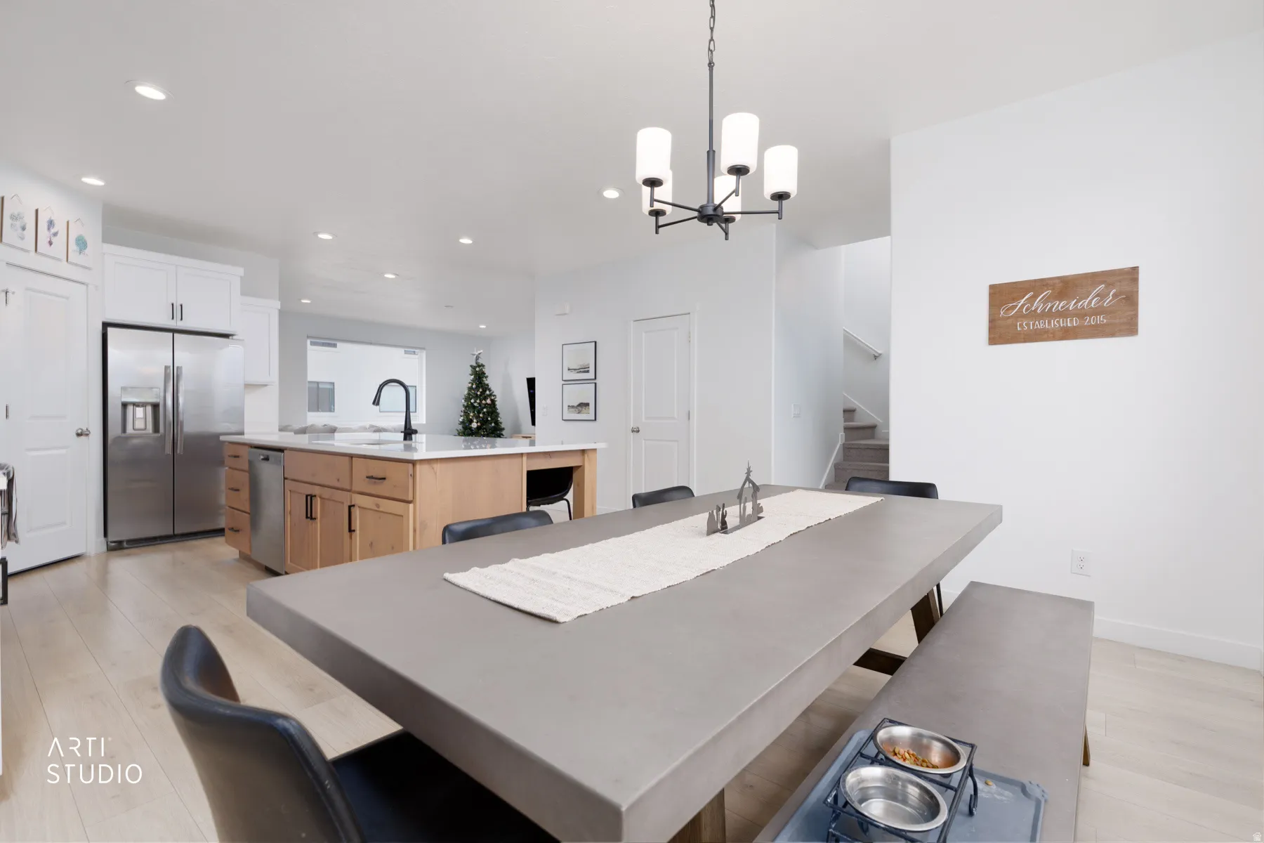 Dining space featuring stairs, light wood-type flooring, a chandelier, and recessed lighting