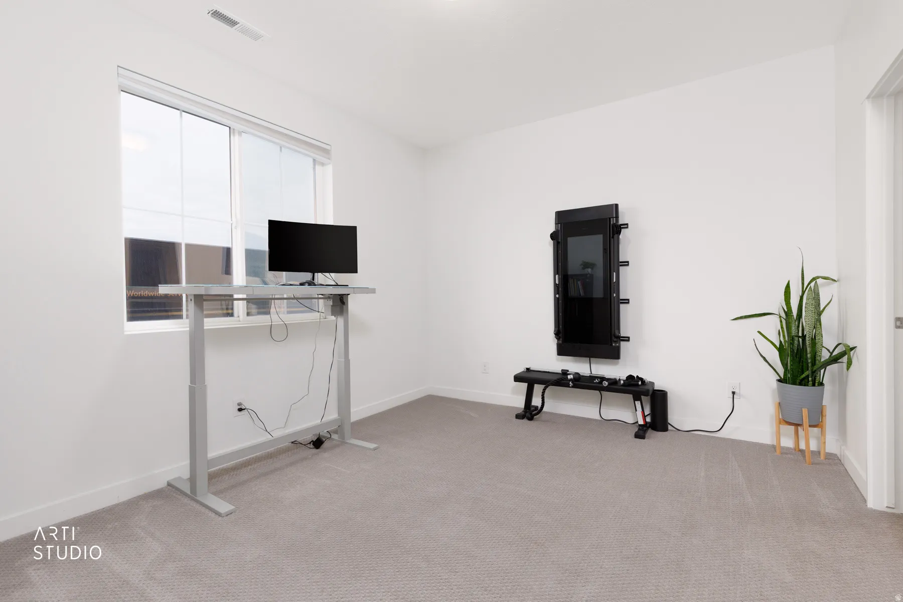 Exercise area featuring light carpet and baseboards