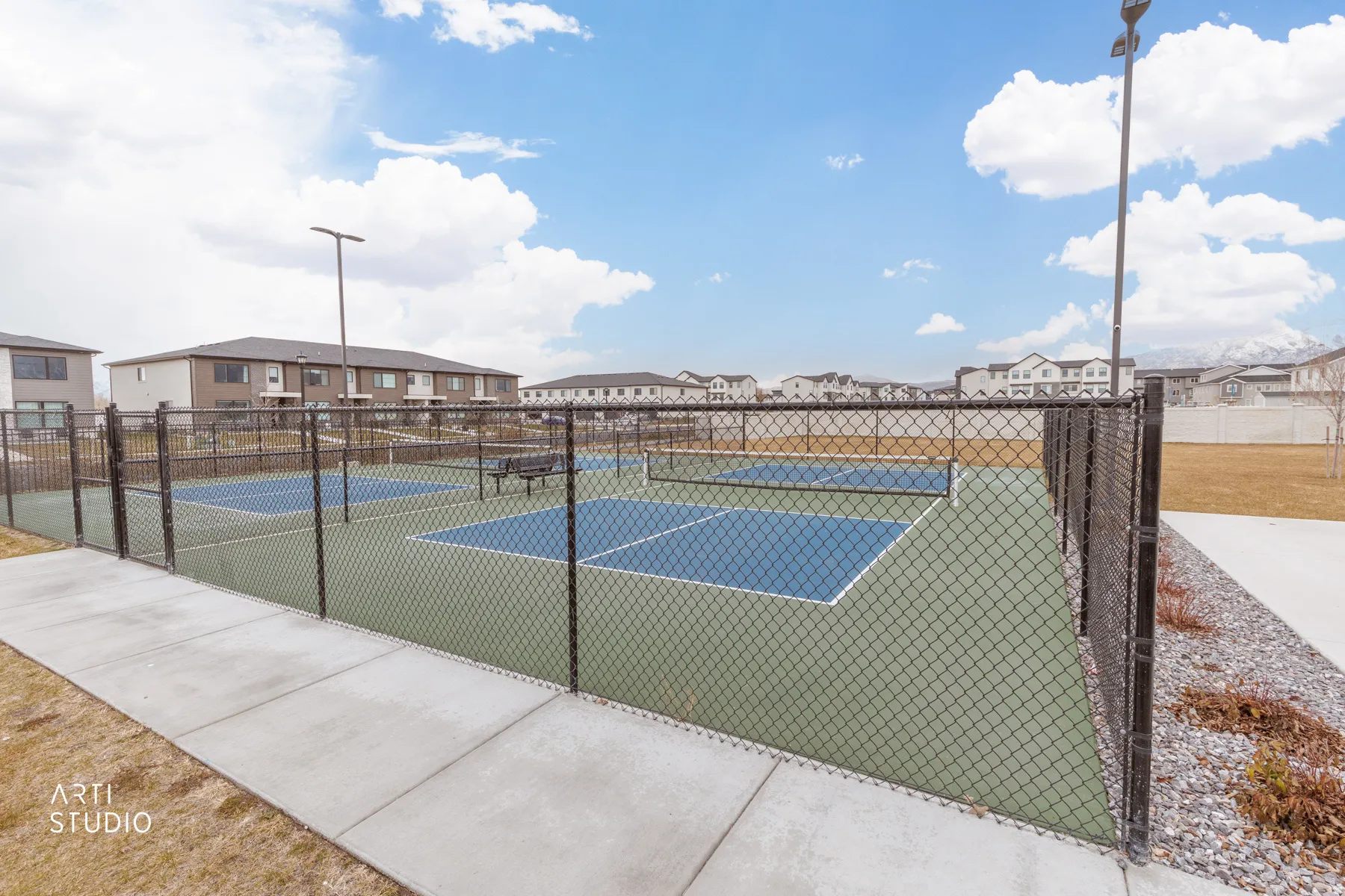 View of tennis court with a residential view